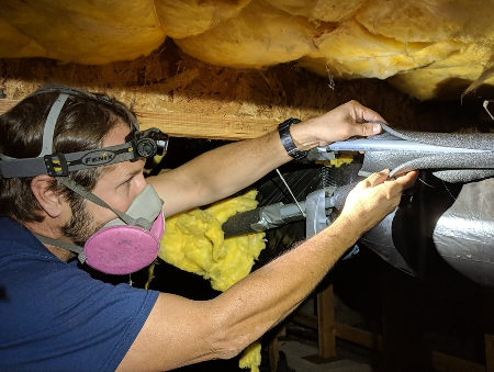 45th Parallel inspector looking at the crawlspace of a home.