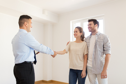 Happy couple and realtor shaking hands at new home to help illustrate what's included in a Detailed Home inspection